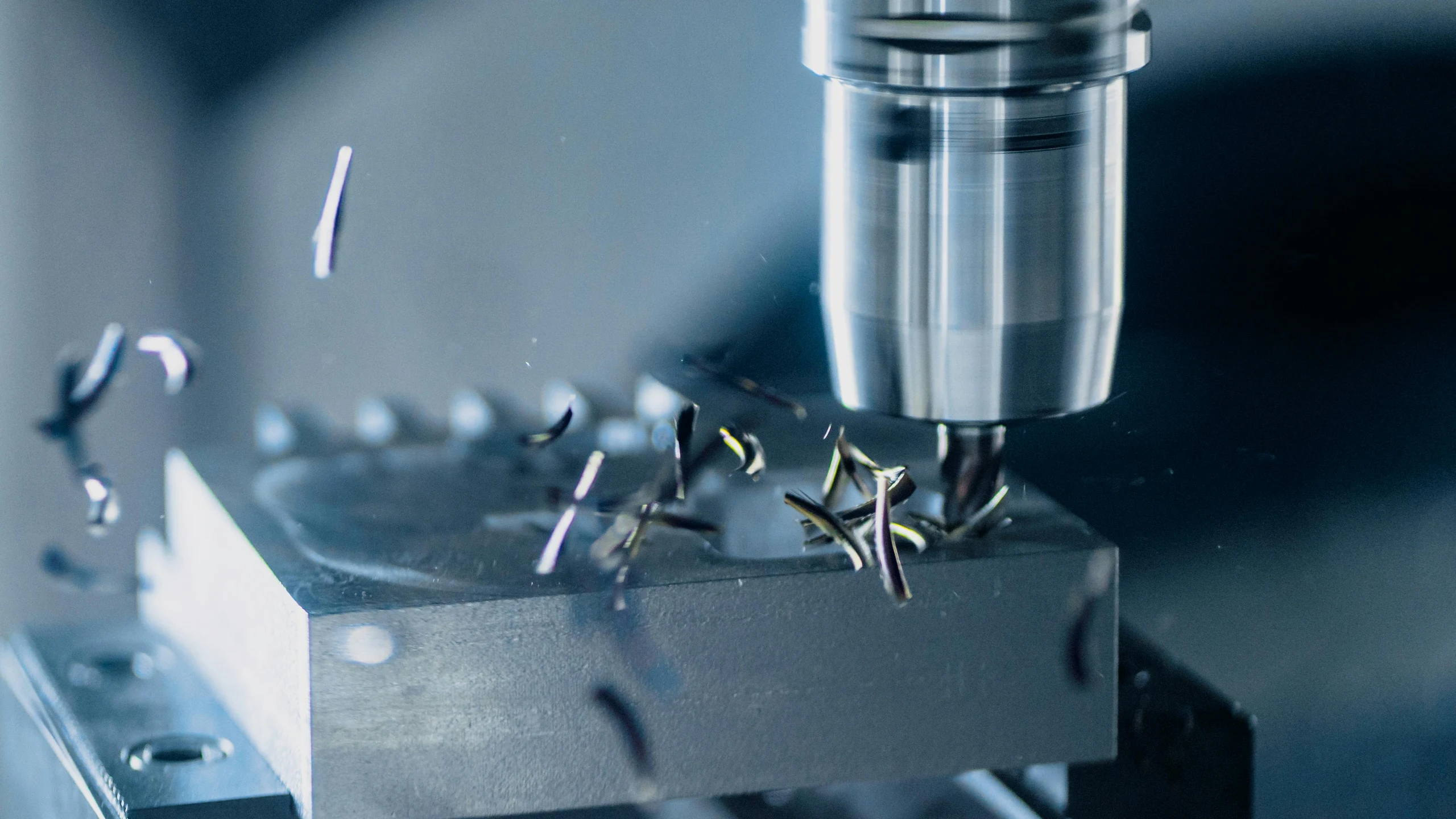 Close-up CNC machining of a metal component in a workshop.