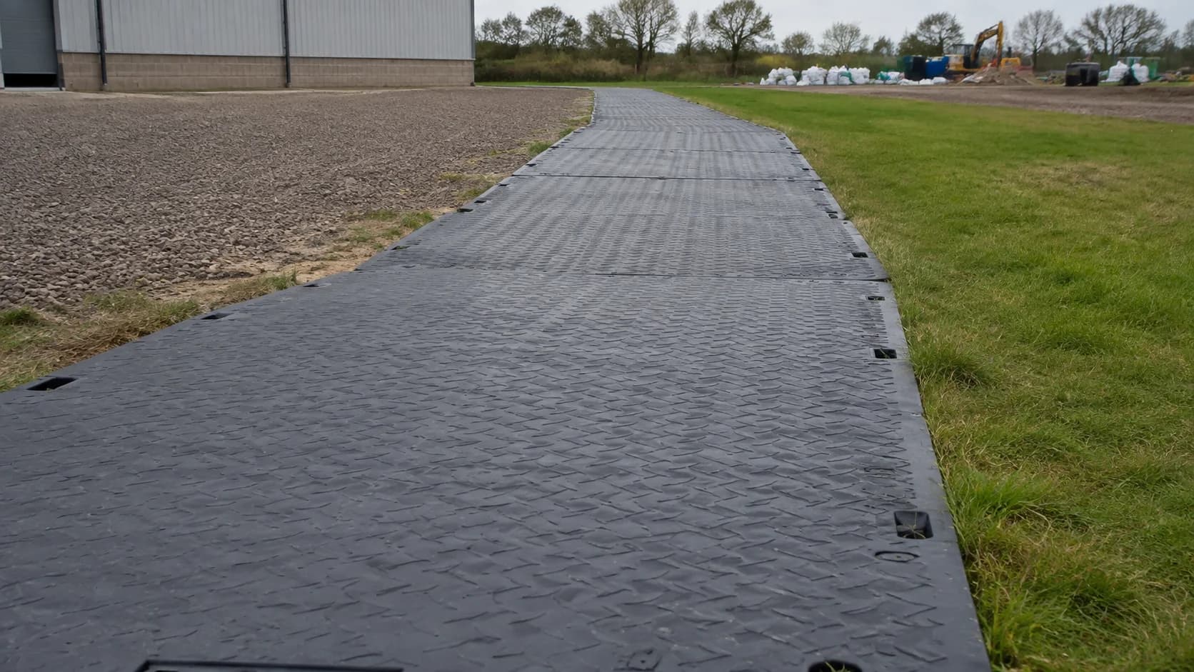 Ground protection mats installed as a temporary route at a commercial worksite.