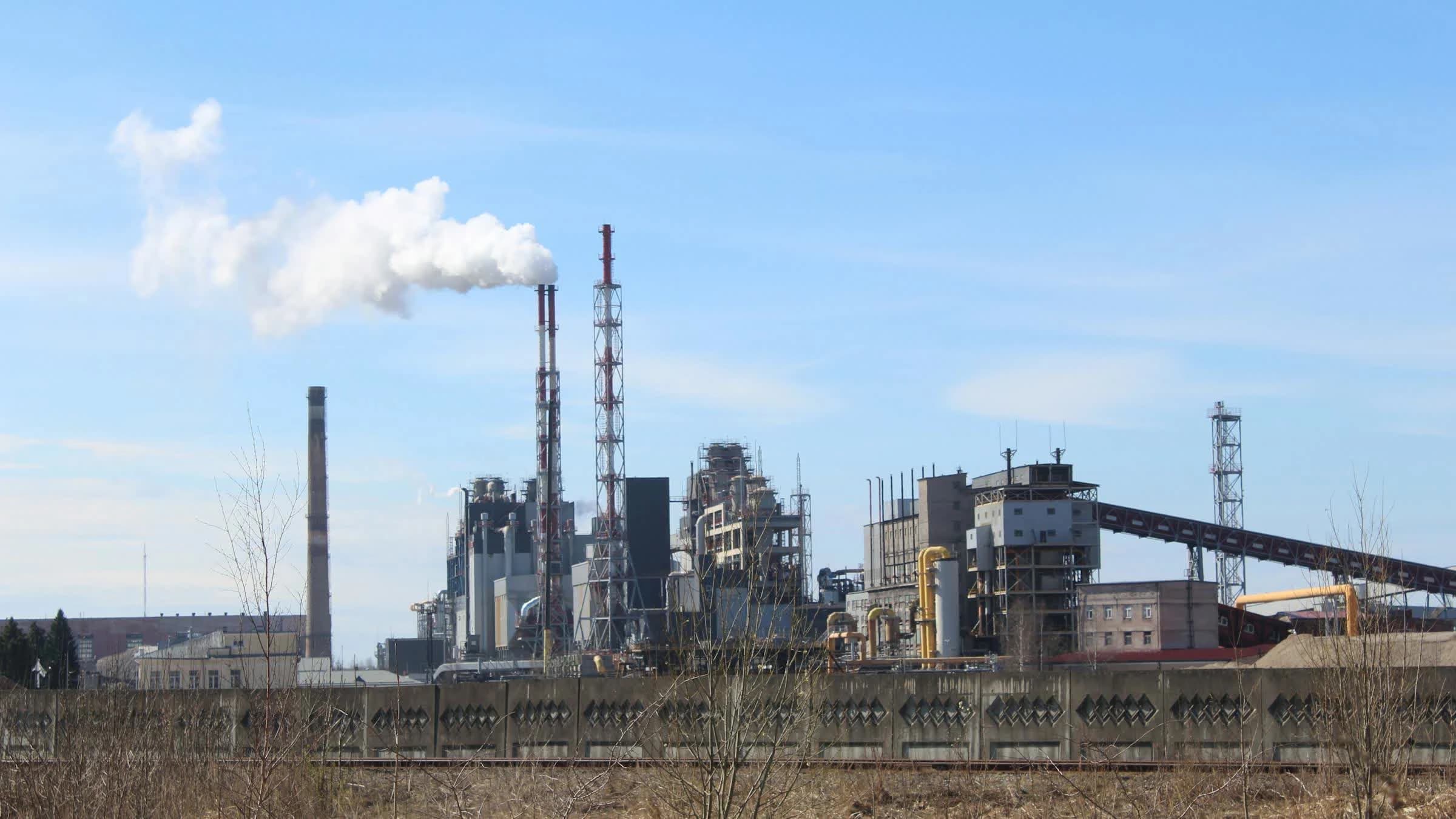 Industrial factory with emissions under a clear sky.